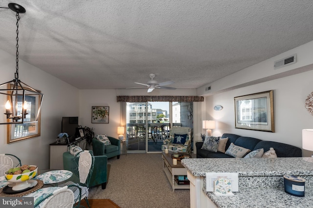 living area with carpet floors, visible vents, a textured ceiling, and ceiling fan with notable chandelier