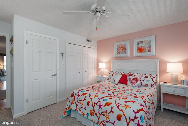 bedroom with carpet floors, a closet, visible vents, ceiling fan, and a textured ceiling