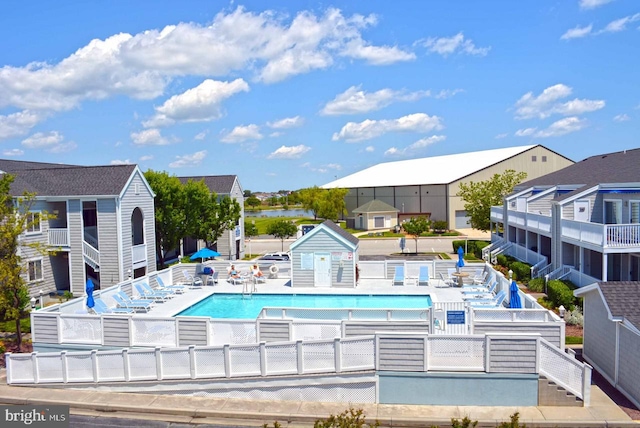 pool with a water view, a patio, and fence