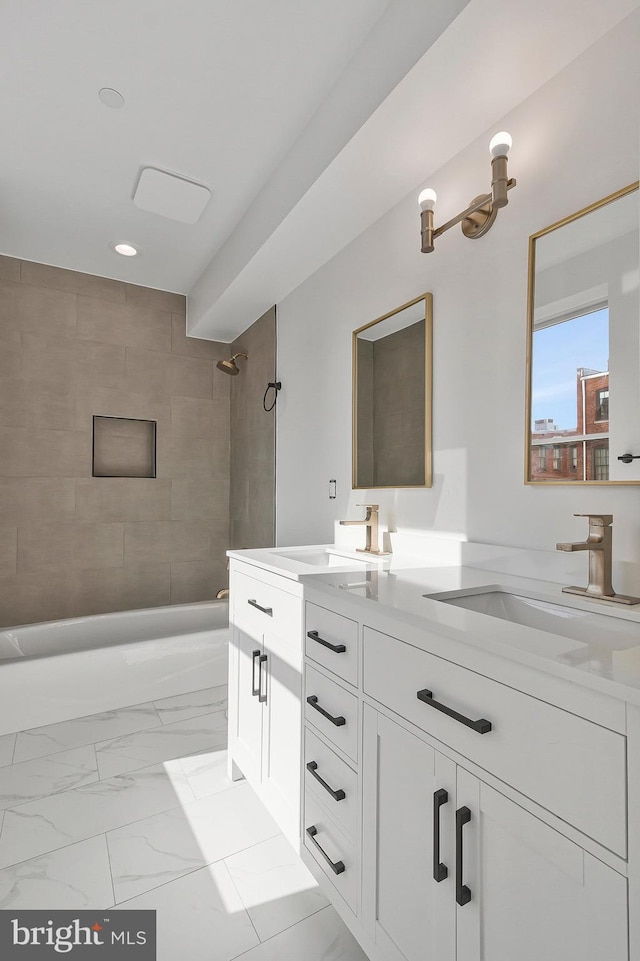 bathroom featuring tiled shower / bath and vanity