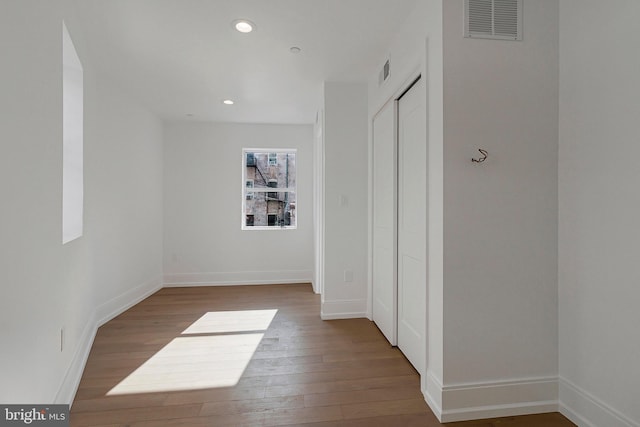 hallway with hardwood / wood-style floors