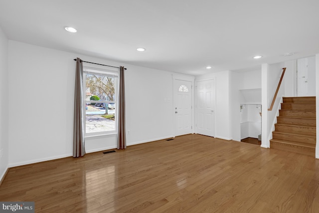 foyer featuring light wood-type flooring, visible vents, recessed lighting, baseboards, and stairs