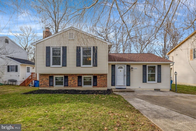 split level home with a front lawn, brick siding, and a chimney