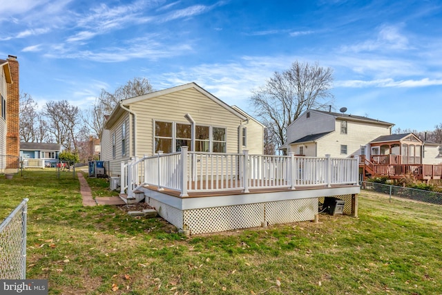 rear view of house with a wooden deck, a residential view, a lawn, and a fenced backyard