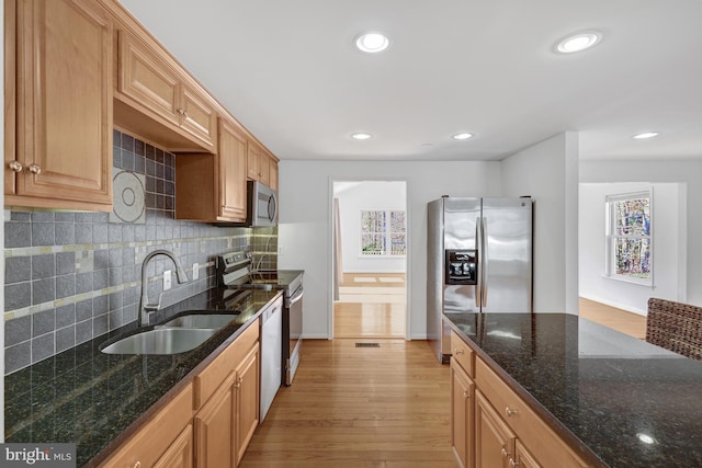 kitchen with recessed lighting, a sink, stainless steel appliances, light wood-type flooring, and backsplash