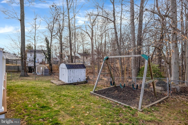 view of playground featuring a fenced backyard, a storage shed, an outdoor structure, and a lawn