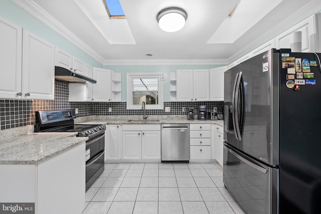 kitchen with a sink, a skylight, appliances with stainless steel finishes, and under cabinet range hood
