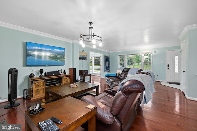 living room featuring a chandelier, ornamental molding, baseboards, and hardwood / wood-style floors
