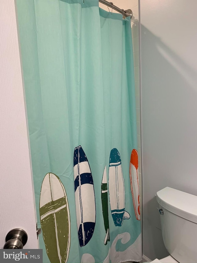 bathroom featuring toilet and a shower with curtain