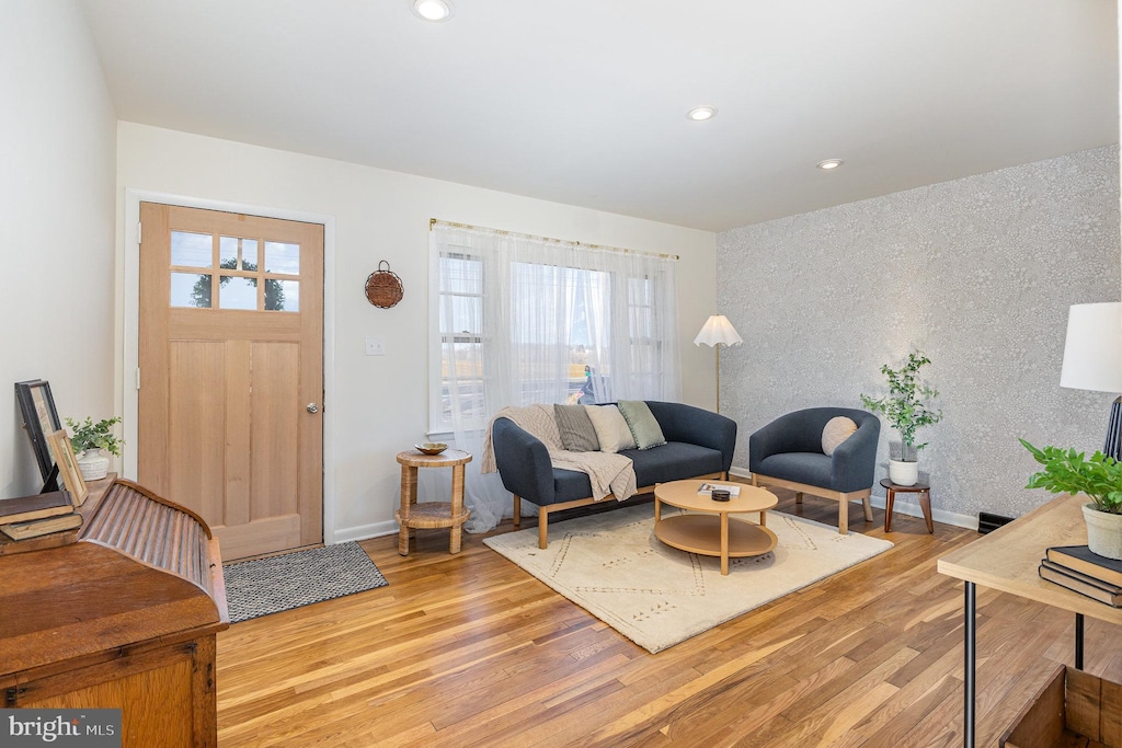 living area with recessed lighting, light wood-style flooring, baseboards, and wallpapered walls