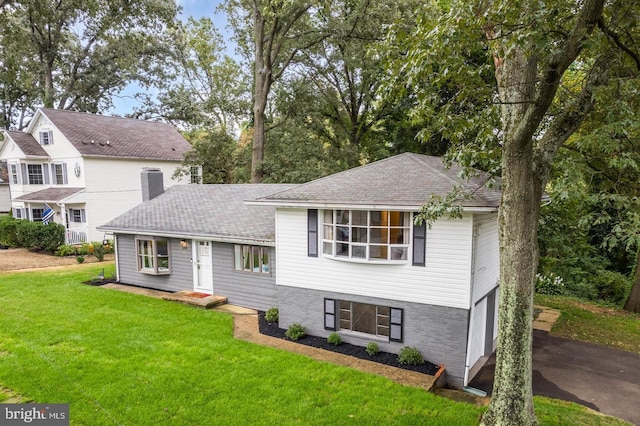 split level home with a garage and a front lawn