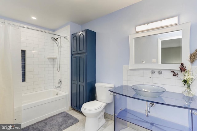 full bathroom featuring tasteful backsplash, sink, toilet, and shower / bathtub combination with curtain