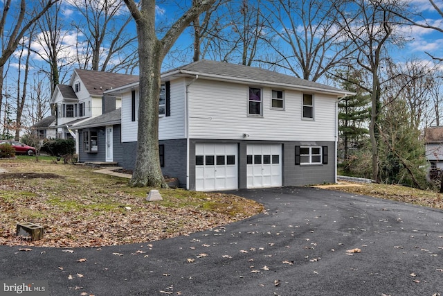 view of side of home featuring driveway and an attached garage