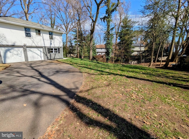 view of yard featuring driveway and a garage