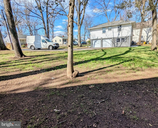 view of yard featuring driveway and a garage