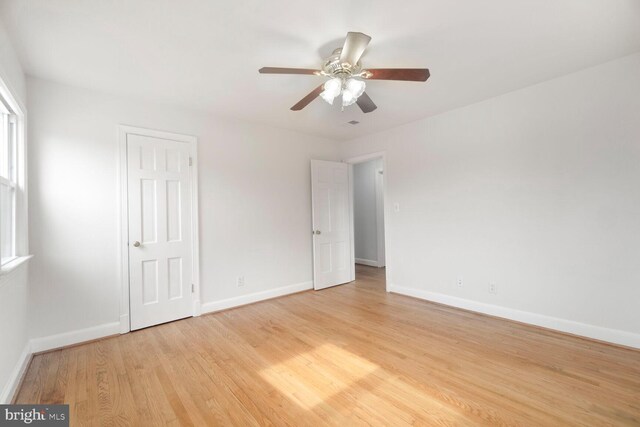 unfurnished bedroom featuring a ceiling fan, baseboards, and light wood finished floors