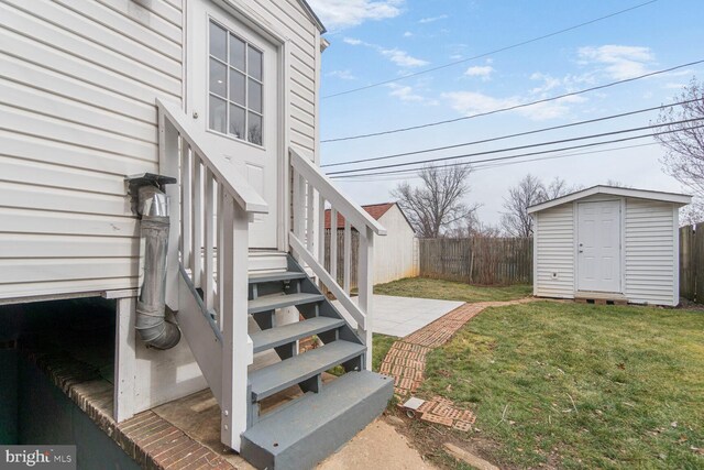 view of yard featuring an outbuilding, a storage unit, a patio area, and fence