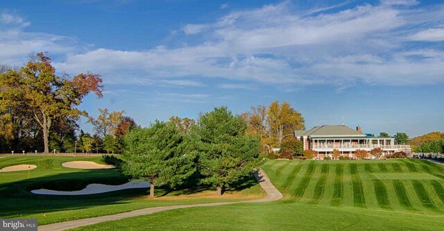 view of community with view of golf course and a yard