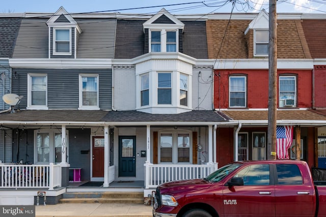 townhome / multi-family property featuring covered porch and cooling unit