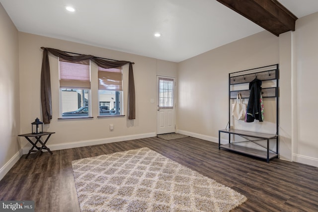 entryway with dark wood-type flooring and beam ceiling