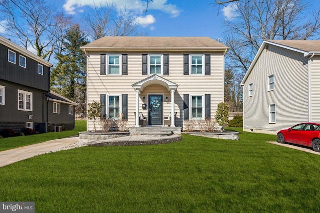 colonial house featuring a front lawn and central air condition unit