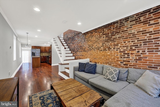 living room featuring ornamental molding, brick wall, and dark hardwood / wood-style floors