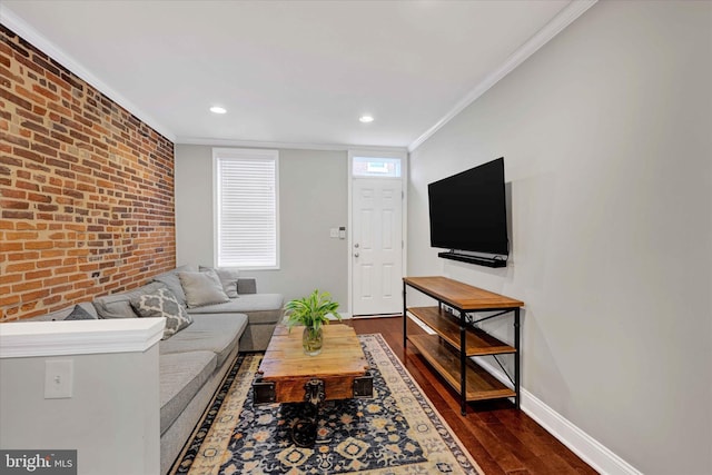 living room featuring crown molding, dark hardwood / wood-style floors, and brick wall