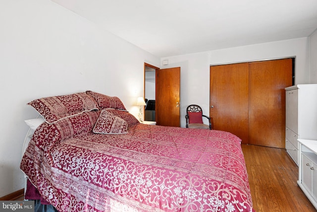 bedroom with light hardwood / wood-style floors and a closet