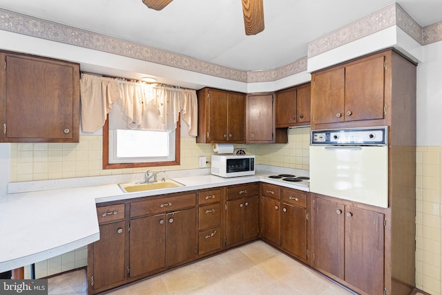 kitchen with ceiling fan, white appliances, sink, and backsplash