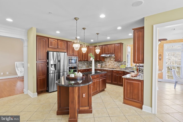 kitchen with a center island, hanging light fixtures, light tile patterned floors, appliances with stainless steel finishes, and dark stone counters