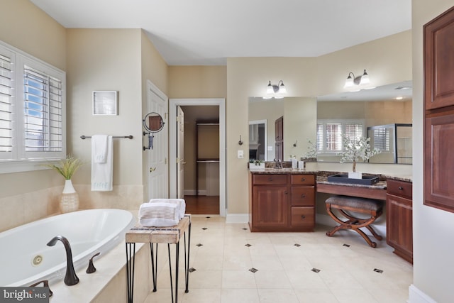 bathroom featuring vanity, tile patterned flooring, and tiled bath