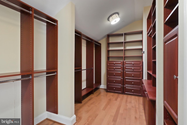 walk in closet with lofted ceiling and light wood-type flooring