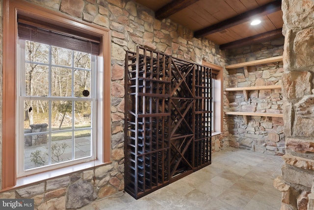 wine room featuring wood ceiling and beam ceiling