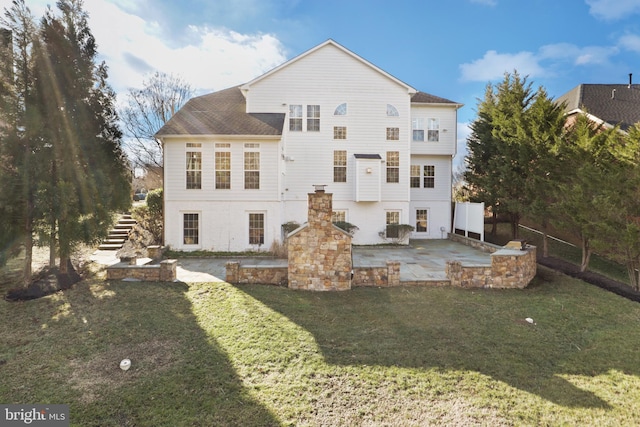 back of house with a patio area and a lawn