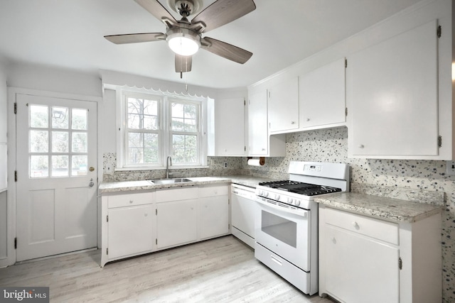 kitchen featuring dishwashing machine, sink, white cabinetry, and white gas range oven