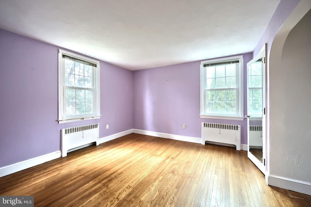 interior space with radiator heating unit and hardwood / wood-style floors