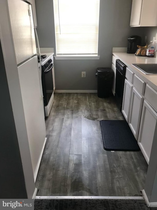 kitchen with sink, range with gas cooktop, white cabinetry, dark hardwood / wood-style flooring, and black dishwasher