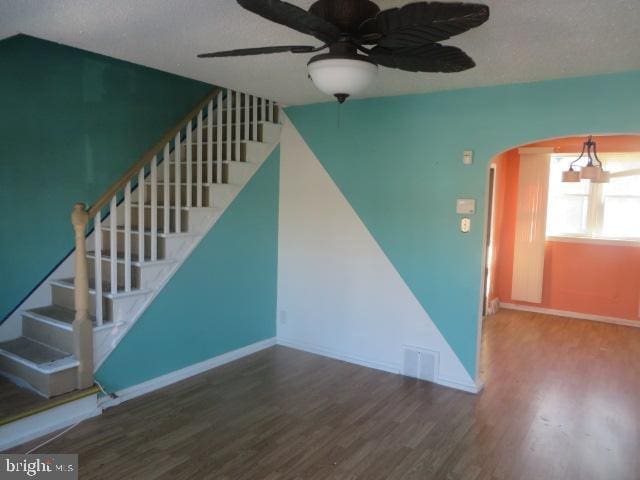 stairway featuring hardwood / wood-style flooring, a textured ceiling, and ceiling fan