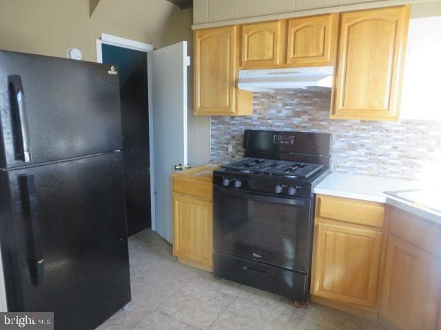 kitchen with light tile patterned floors, decorative backsplash, and black appliances