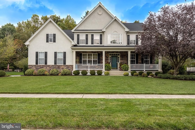 view of front of property with stone siding, a front lawn, covered porch, and stucco siding