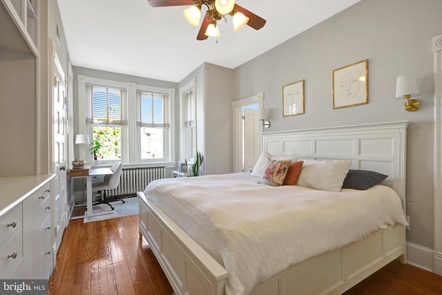 bedroom with dark wood-type flooring, radiator heating unit, baseboards, and ceiling fan