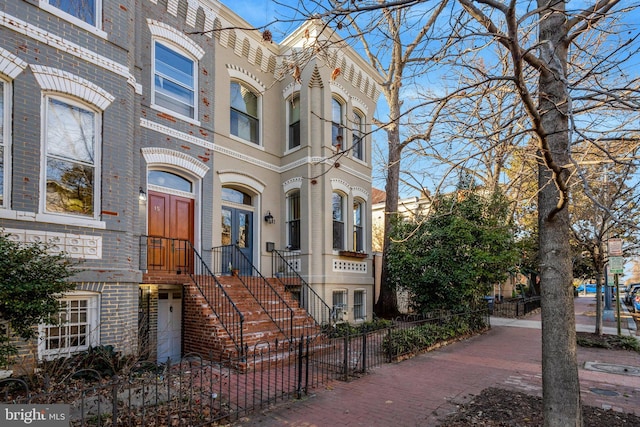 view of front facade with a fenced front yard and brick siding