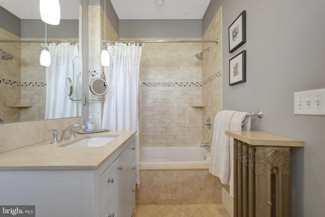 bathroom featuring tile patterned flooring, vanity, and tiled shower / bath