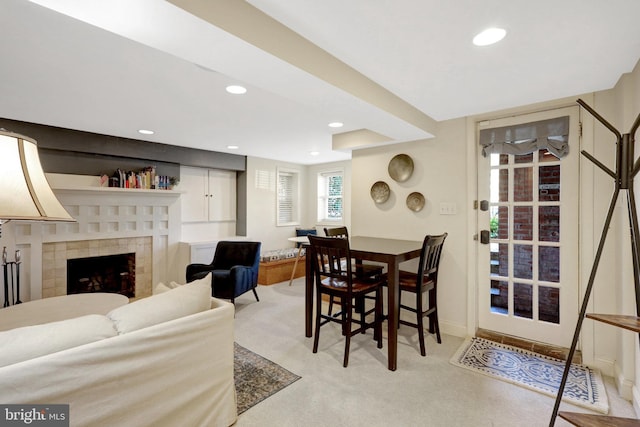 carpeted dining area with recessed lighting, baseboards, and a tile fireplace