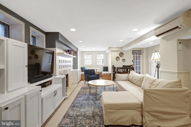 living area with recessed lighting, a fireplace, and a wall unit AC