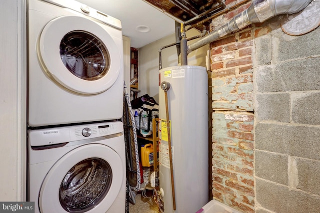 laundry room featuring gas water heater, brick wall, and stacked washing maching and dryer