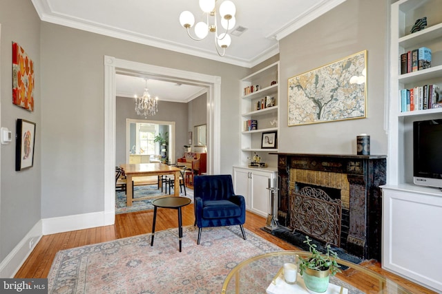 interior space with built in shelves, baseboards, light wood-style flooring, a fireplace, and a chandelier