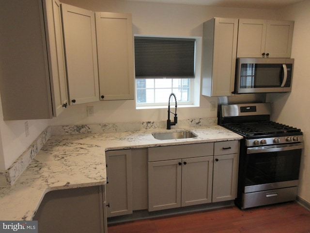 kitchen featuring light stone counters, sink, white cabinets, and appliances with stainless steel finishes