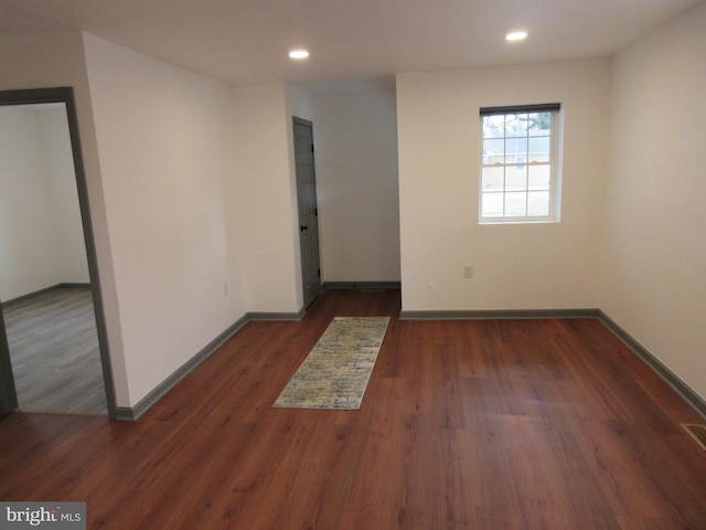 empty room with dark hardwood / wood-style flooring