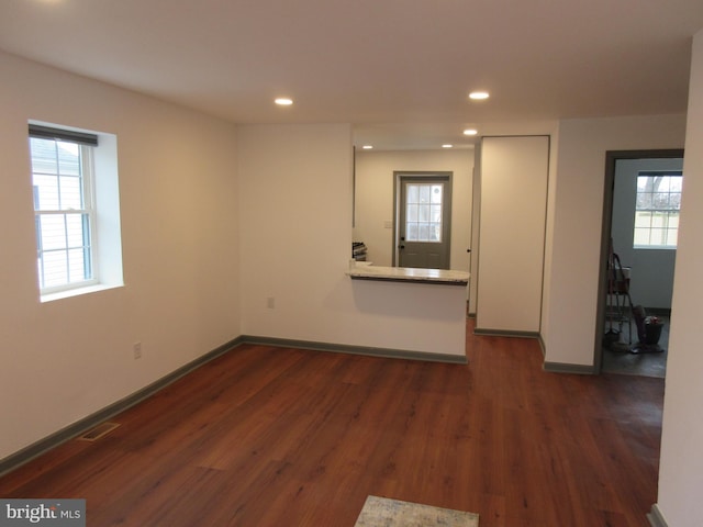 spare room with dark wood-type flooring and a healthy amount of sunlight